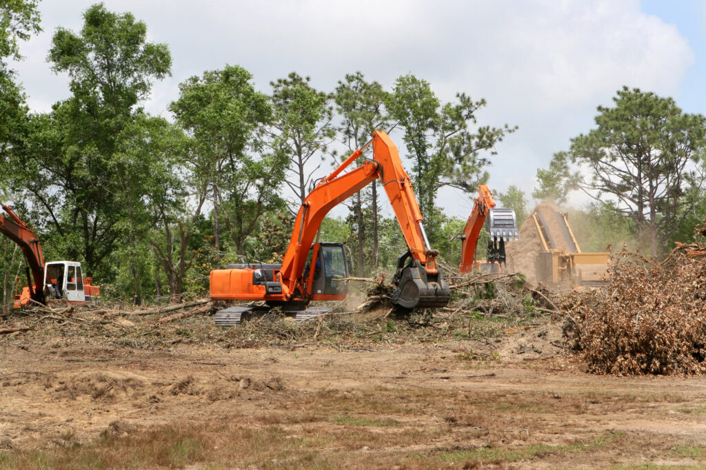 Excavators clearing land in Chalmette, preparing the area for new construction or landscaping projects.